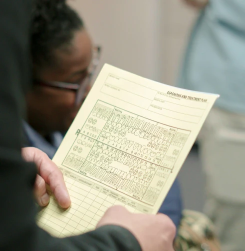 Patient reviewing dental insurance paperwork with guidance from clinic staff.