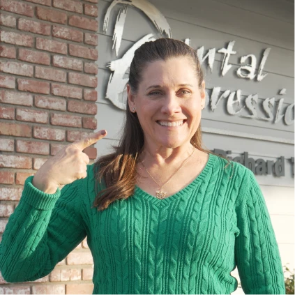 Happy dental patient smiling outside the clinic after cosmetic treatment.